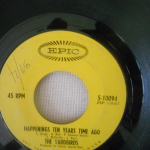 May include: A yellow vinyl record label with black text. The label is for the song "Happenings Ten Years Time Ago" by The Yardbirds. The label is from Epic Records and has the catalog number 5-10094.