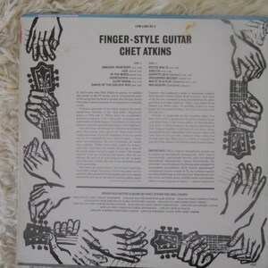 May include: Black and white album cover with the title "Finger-Style Guitar Chet Atkins" and a list of songs on the album. The cover features a series of illustrations of hands playing a guitar.