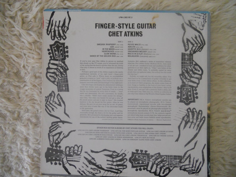 May include: Black and white album cover with the title "Finger-Style Guitar Chet Atkins" and a list of songs on the album. The cover features a series of illustrations of hands playing a guitar.