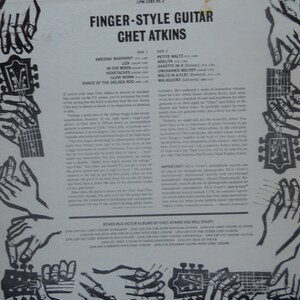 May include: A vintage record album cover featuring a black and white illustration of hands playing a guitar. The album is titled "Finger-Style Guitar Chet Atkins" and lists the songs on each side of the record.