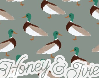 May include: A seamless pattern featuring a repeating design of brown and white ducks with green heads. The ducks are arranged in a staggered pattern on a light green background. The text "Honey & Jive" is written in a white cursive font in the center of the image.