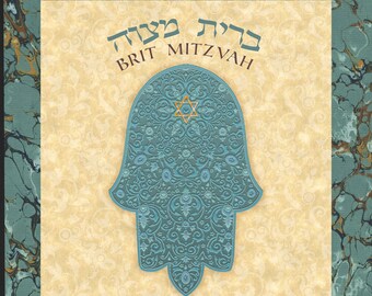 May include: A blue and gold Hamsa hand with intricate floral designs. The text "Brit Mitzvah" is written in Hebrew at the top of the image. The name "Ariel Michael Solomon" is written below the Hamsa hand. The date "January 28, 2017 - 1 Shevat 5777" and the text "Parashot Vaera" are written below the name.