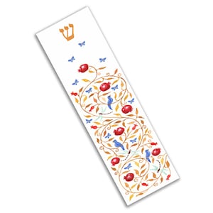 Puede incluir: Una mezuzah blanca con una letra hebrea Shin dorada y un dise&ntilde;o decorativo de una vid con granadas rojas, p&aacute;jaros azules y mariposas.