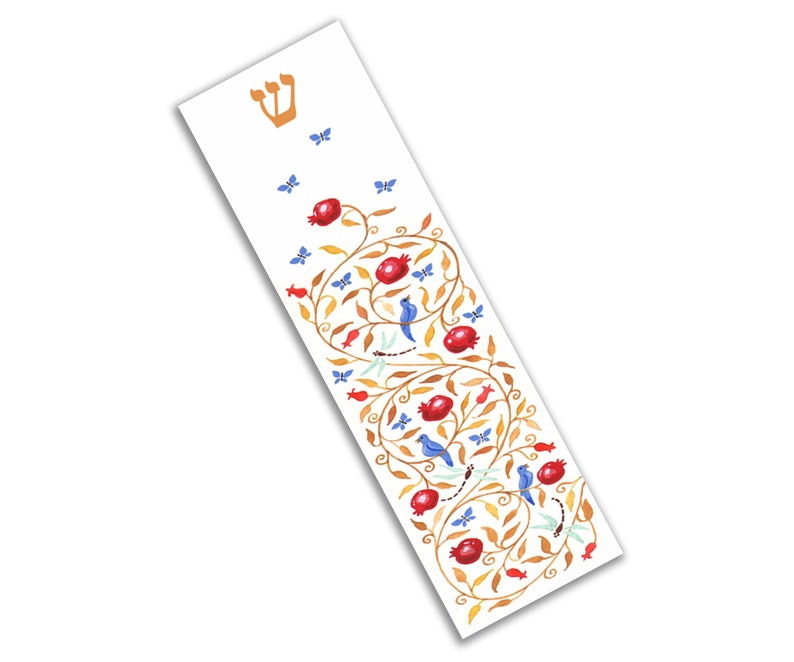 Puede incluir: Una mezuzah blanca con una letra hebrea Shin dorada y un dise&ntilde;o decorativo de una vid con granadas rojas, p&aacute;jaros azules y mariposas.