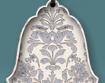 May include: Silver key chain with a hamsa charm. The charm is decorated with a white and gray floral pattern.