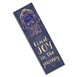Peut inclure: Signet de livre en forme de main de Hamsa bleu et or avec le mot h&eacute;breu pour "protection" et le texte "Trouvez la joie dans le voyage" sur un fond bleu fonc&eacute; avec des &eacute;toiles blanches.