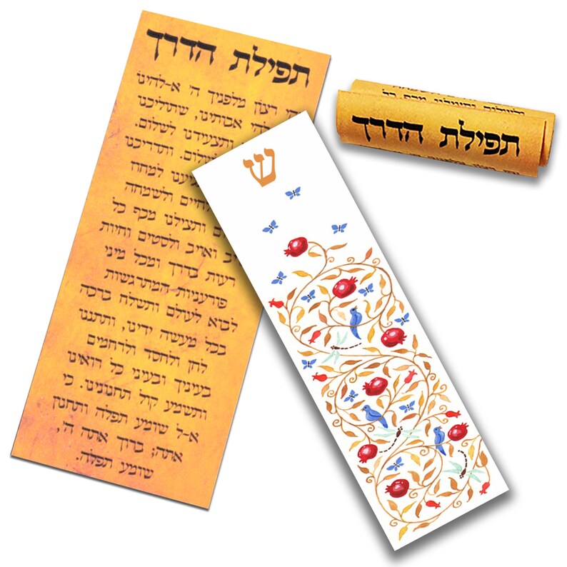 Puede incluir: Un marcap&aacute;ginas blanco con un dise&ntilde;o de &aacute;rbol de granada dorado y rojo. El marcap&aacute;ginas est&aacute; decorado con p&aacute;jaros azules, mariposas y lib&eacute;lulas. El texto "תפילת הדרך" est&aacute; escrito en hebreo en un rollo enrollado en el fondo.
