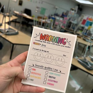 May include: A light brown card with the text "WARNING! reading this note will make you smile!" and a pencil icon. The card has a section for "I want to brag on" with three smiley faces and a section for "Character qualities I saw" with a checklist of positive character traits.