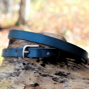 Blue skinny leather belt that is 1/2 inch wide with a nickel matt buckle.