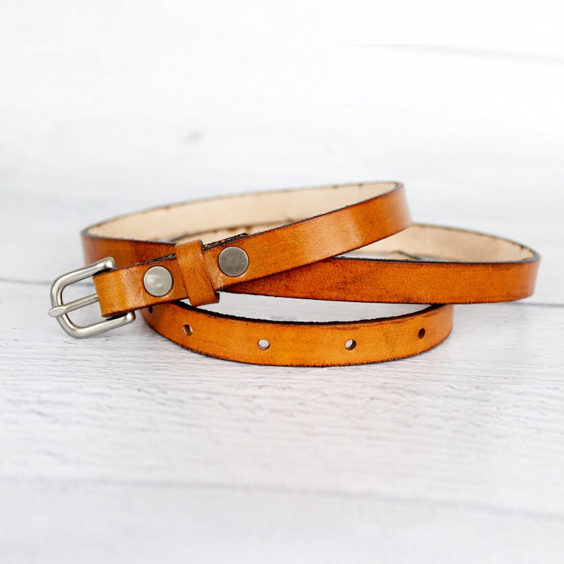 Tan women's belt showing that the keeper is secured by rivets.