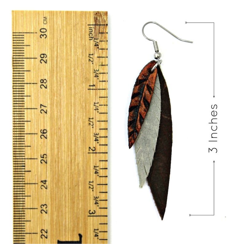 May include: A pair of leather feather earrings in brown, orange, and gray. The earrings are 3 inches long.