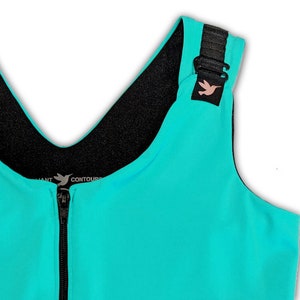 May include: A turquoise sports bra with black straps and a zip at the front. The bra has a black lining and a small hummingbird logo on the strap. The text "CONTOURS" is printed on the bra.