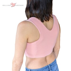 May include: A pink ribbed tank top with a white trim. The tank top is cropped and has a V-neck.