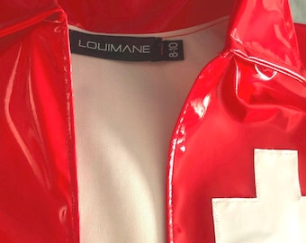 May include: Red vinyl jacket with a white cross on the back and a black label with the text "LOUIMANE" and "8-10" on the front.