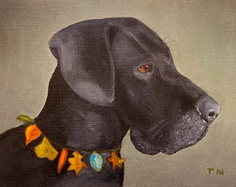 May include: A black dog with brown eyes, wearing a necklace of colorful leaves and stones, is looking to the right. The dog's fur is smooth and shiny. The background is a light gray.