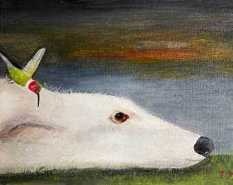 May include: A white dog with brown eyes is lying down with a green and red hummingbird perched on its head. The background is a dark blue and green.