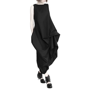 May include: A black sleeveless dress with a flowing, asymmetrical design. The dress is made of a lightweight fabric and has a relaxed fit.