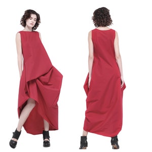 May include: A red sleeveless dress with a flowing, asymmetrical hemline. The dress is made of a lightweight fabric and has a relaxed fit.