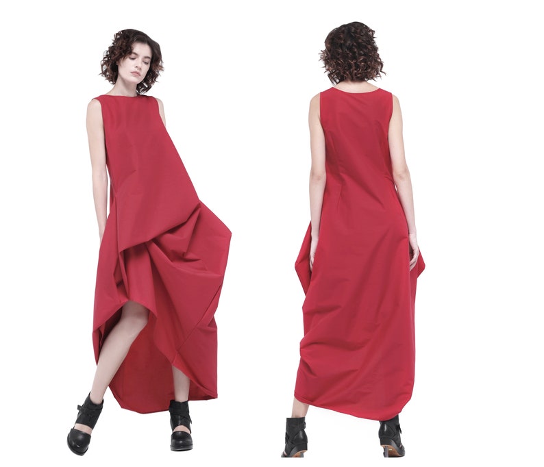 May include: A red sleeveless dress with a flowing, asymmetrical hemline. The dress is made of a lightweight fabric and has a relaxed fit.