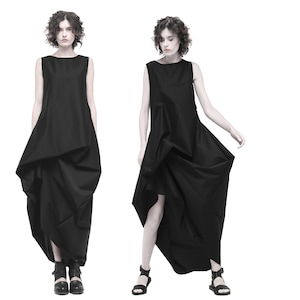 May include: A black sleeveless dress with a flowing, asymmetrical skirt. The dress is made of a lightweight fabric and has a simple, elegant design.