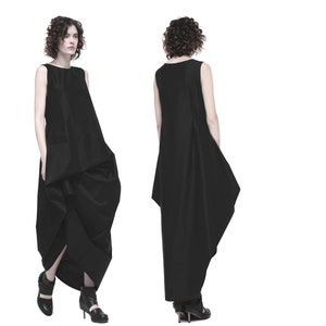 May include: A black sleeveless dress with a flowing, asymmetrical skirt. The dress is made of a smooth, lightweight fabric.