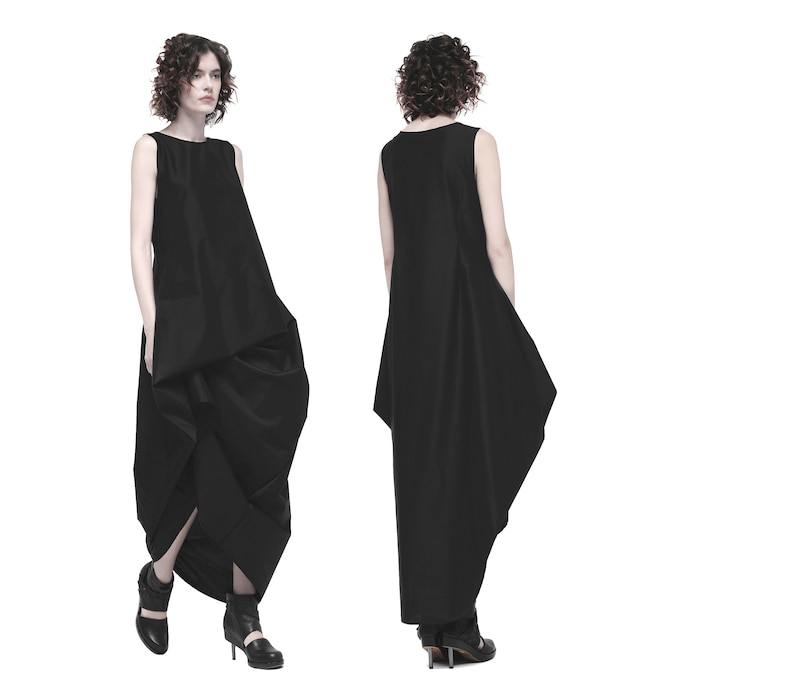 May include: A black sleeveless dress with a flowing, asymmetrical skirt. The dress is made of a smooth, lightweight fabric.