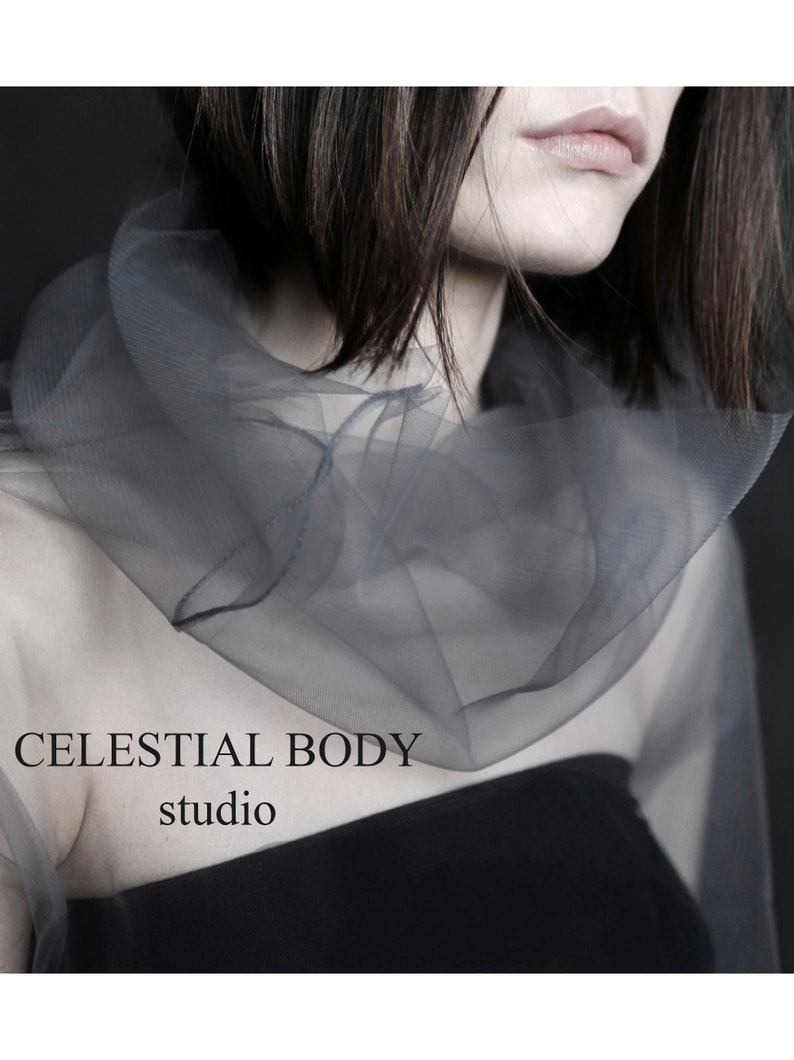 May include: A woman wearing a sheer gray top with a black tank top underneath. The text "CELESTIAL BODY studio" is visible on the image.
