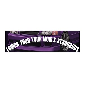 Puede incluir: Una pegatina para parachoques de coche morado con el texto "Lower Than Your Mom's Standards" en blanco. La pegatina muestra una vista parcial de un coche morado con una rueda plateada.