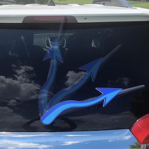 May include: Blue arrow car decal. The decal features three blue arrows with a gradient effect, applied to the rear window of a vehicle. The arrows point in different directions, creating a dynamic visual.