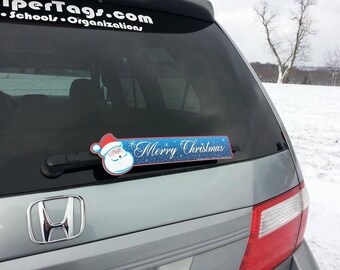 Merry Christmas SANTA WiperTag attaches to rear vehicle wiper blades. Detachable, interchangeable, and weather resistant. Made in the USA.