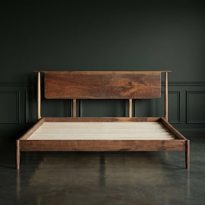 May include: A handcrafted wooden bed frame with a natural wood headboard. The bed frame is made of dark brown wood with a light-colored wooden slat base. The headboard has a live edge design. The bed frame is a modern design.