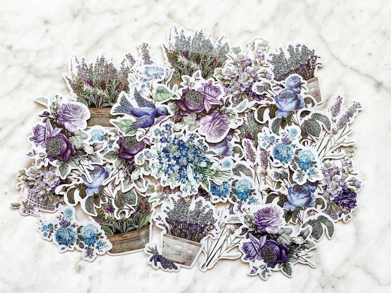 K&ouml;nnte beinhalten: Eine Sammlung von Lavendel- und Blumenstickern mit einem blauen Vogel, perfekt zum Scrapbooking, Journaling oder um deinen Bastelarbeiten einen Hauch von Verspieltheit zu verleihen.