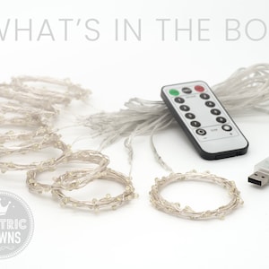 May include: A set of white LED fairy lights with a remote control and USB adapter. The lights are strung together in a long strand and can be used to decorate a home or party.