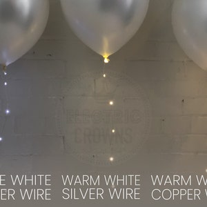 May include: Three white balloons with string lights. The text at the bottom reads "Pure White Silver Wire", "Warm White Silver Wire", and "Warm White Copper Wire". The lights are small and round.