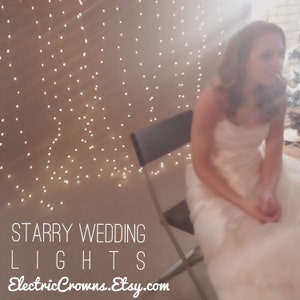 May include: A bride sits in a chair in front of a wall decorated with white fairy lights. The text "Starry Wedding Lights ElectricCrowns.Etsy.com" is at the bottom of the image.