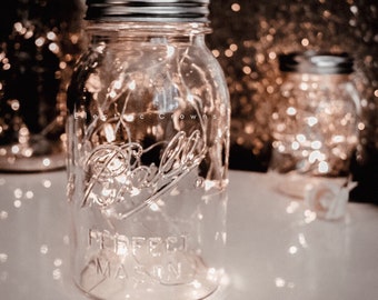 May include: A mason jar with a silver lid filled with white fairy lights. The jar has the words "Perfect Mason" printed on the side. The text "Electric Crowns" is visible in the background.