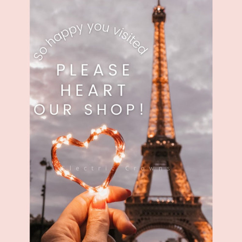 Puede incluir: Una cadena de luces con forma de coraz&oacute;n sostenida frente a la Torre Eiffel en Par&iacute;s, Francia. El texto "so happy you visited PLEASE HEART OUR SHOP!" est&aacute; escrito en blanco sobre un fondo rosa. El texto "Electric Crowns" est&aacute; escrito en blanco sobre un fondo negro.
