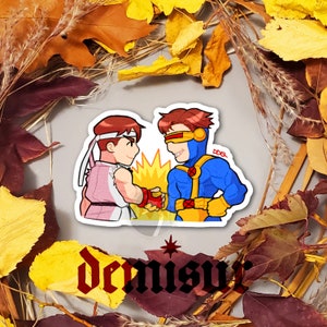 May include: A sticker featuring two cartoon characters shaking hands. The character on the left is wearing a pink and white outfit and has brown hair. The character on the right is wearing a blue and yellow outfit and has brown hair. The sticker has a white background and the text "Dennis" is printed below the characters.