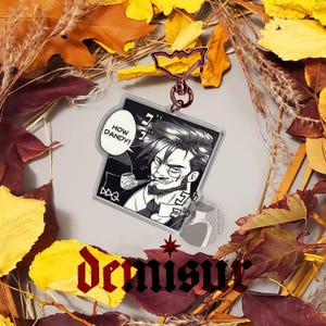 May include: A black and white illustration of a man with a mustache and beard, wearing a suit and tie, smoking a pipe. The man is looking to the right and has a speech bubble above his head that says "How Dandy!" The illustration is printed on a clear acrylic keychain.