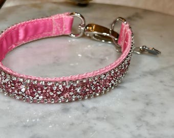 May include: Pink velvet dog collar with a silver clasp and a row of pink rhinestones.
