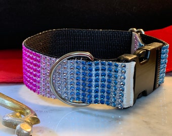 May include: A black dog collar with a pink, white, and blue ombre rhinestone design. The collar has a silver D-ring and a black plastic buckle.