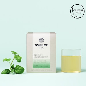 May include: A box of OSULLOC Basil Botanic Garden tea with a glass of tea and fresh basil sprigs. The box has text in English and Korean, and a "Caffeine Free" logo. The tea is a light yellow color.