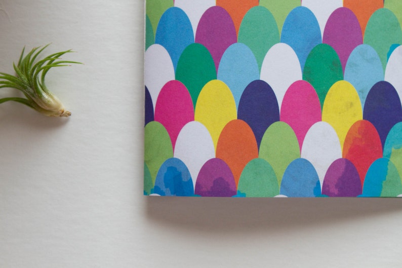 Puede incluir: Una cubierta de cuaderno colorida con un patr&oacute;n de c&iacute;rculos superpuestos en tonos de azul, verde, morado, amarillo, naranja, rosa y blanco.