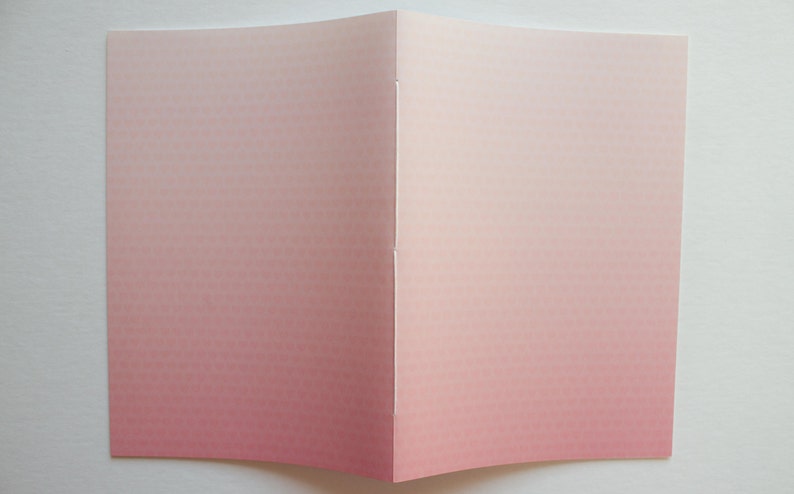 May include: A folded card with a pink to white ombre gradient. The card is blank and ready for writing.