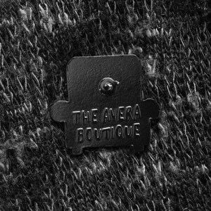 Peut inclure: &Eacute;pinglette en m&eacute;tal noir en forme de fauteuil avec le texte "THE AVERA BOUTIQUE" dessus.