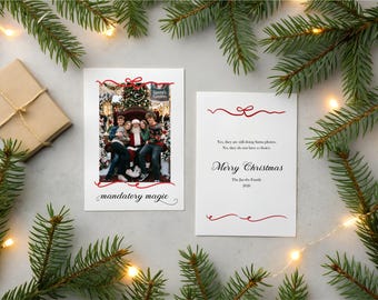 May include: Two rectangular white Christmas cards with red ribbon graphics. The left card features a photograph of a family with Santa Claus and the text "mandatory magic". The right card contains the text "Yes, they are still doing Santa photos, No, they do not have a choice. Merry Christmas The Jacobs Family 2021".