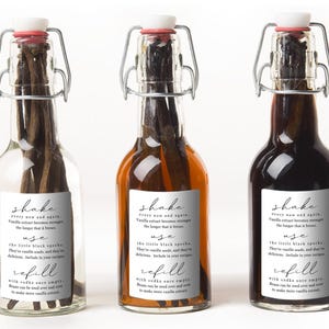 May include: Three clear glass swing-top bottles containing dark vanilla beans. Each bottle features a white rectangular label with black text that reads: shake every now and again, use the little black specks, and refill with vodka once empty.