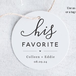 Op de afbeelding: Ronde witte sticker met zwarte tekst die "his FAVORITE" luidt met een klein hartje en de namen Colleen en Eddie en de datum 08.09.24. De sticker is bevestigd aan een stuk touw.