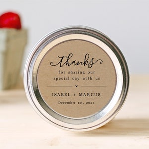 May include: A brown paper favor jar lid with a thank you message for sharing our special day with us. The lid has the names Isabel + Marcus and the date December 1st, 20XX.