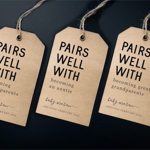 Puede incluir: Tres etiquetas de regalo de papel marrón con el texto "Pairs Well With" y diferentes mensajes sobre convertirse en abuelos, una tía y abuelos. Las etiquetas también incluyen el texto "baby maran arriving February 2023".